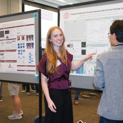 Isabella Elkinbard presents her research at a poster session.