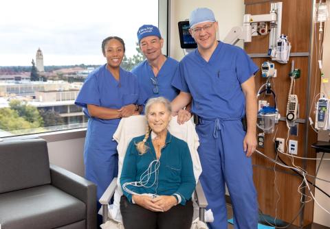Debbie Styles smiles with her surgical team. Standing, from left to right: Tiffany, a research coordinator for the CARDIAC-PND Study, Dr. Martin Angst, and Dr. Igor Feinstein. 