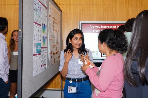 Marwa Zafarullah talks about her research poster with another person.
